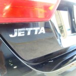 Before and after photographs of a damaged black Volkswagon Jetta that was repaired by Elite Paint & Body Shop in West Palm Beach, Florida.